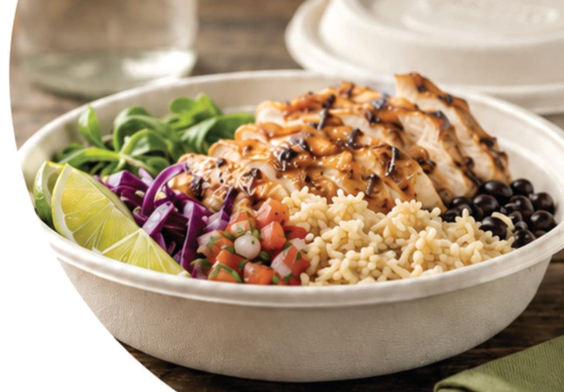 Compostable bagasse fiber bowl filled with a rice and chicken dish